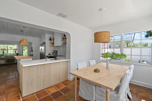 a kitchen with stainless steel appliances kitchen island a table and chairs in it