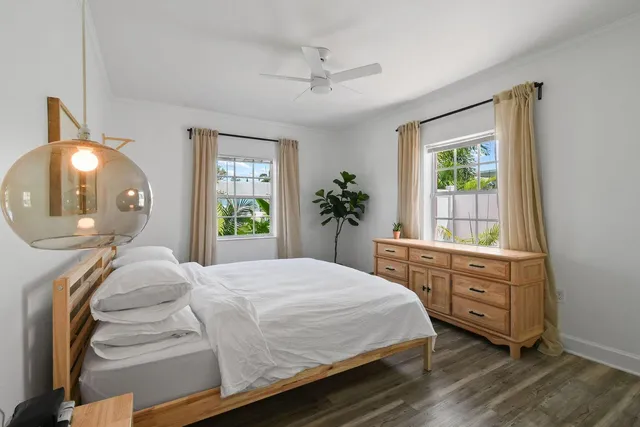 a bedroom with a bed and a mirror on the dresser