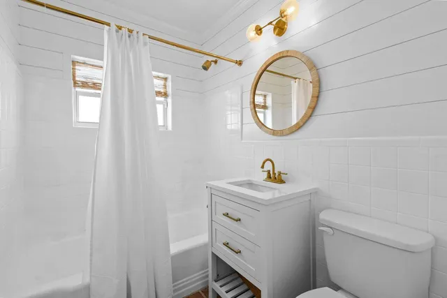 a bathroom with a toilet a sink and a mirror