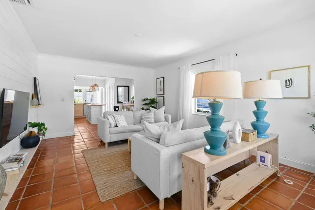 a living room with furniture a rug and white walls