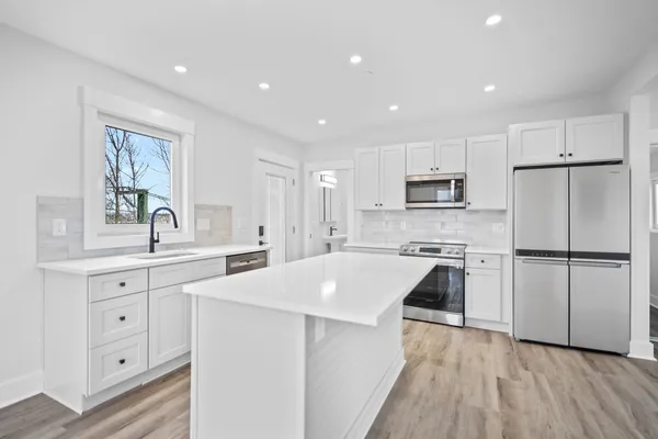 a kitchen with white cabinets and white appliances