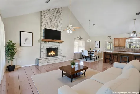 a living room with furniture a flat screen tv and a fireplace