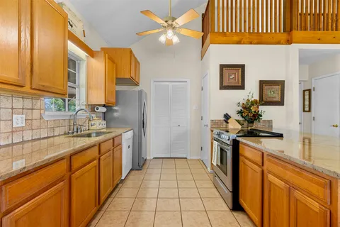 a kitchen with stainless steel appliances kitchen island granite countertop a sink and cabinets