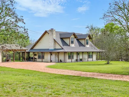 a front view of a house with a yard and trees