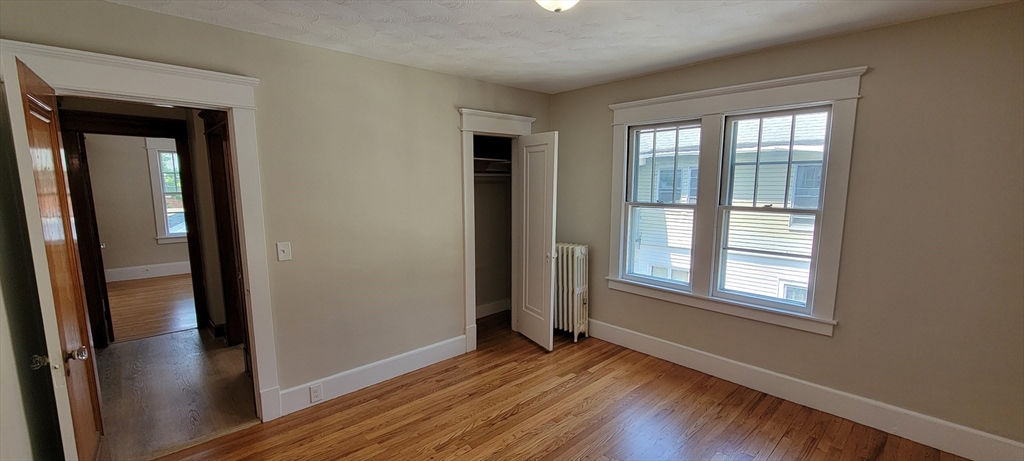 74 Melha Avenue Springfield, MA 01104 - Photo 11 of 16 a view of an empty room with wooden floor and a window