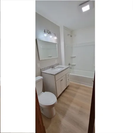 a bathroom with a toilet a sink and mirror