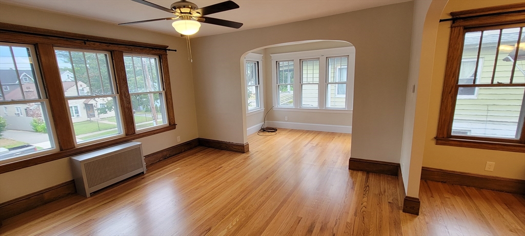 74 Melha Avenue Springfield, MA 01104 - Photo 2 of 16 a view of an empty room with wooden floor and a window