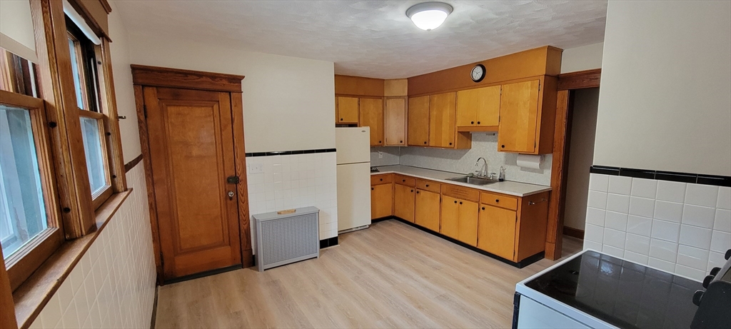 74 Melha Avenue Springfield, MA 01104 - Photo 4 of 16 a kitchen with stainless steel appliances a refrigerator a sink and white cabinets