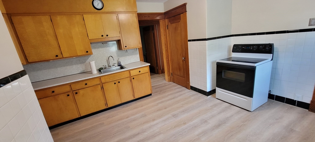74 Melha Avenue Springfield, MA 01104 - Photo 5 of 16 a kitchen with stainless steel appliances a stove a microwave and a refrigerator
