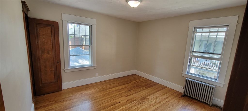 74 Melha Avenue Springfield, MA 01104 - Photo 7 of 16 an empty room with wooden floor and windows