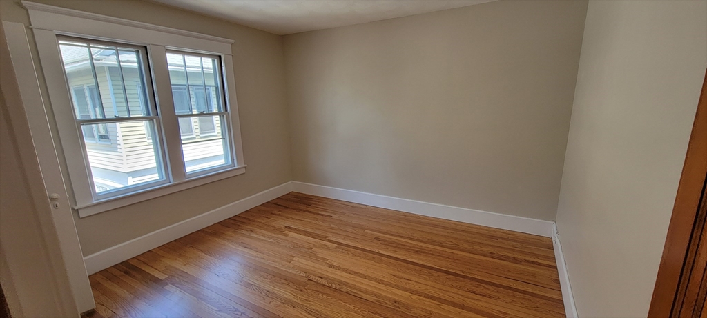 74 Melha Avenue Springfield, MA 01104 - Photo 9 of 16 a view of an empty room with wooden floor and a window
