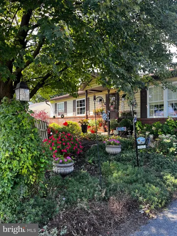 a front view of a house with a garden and sitting area