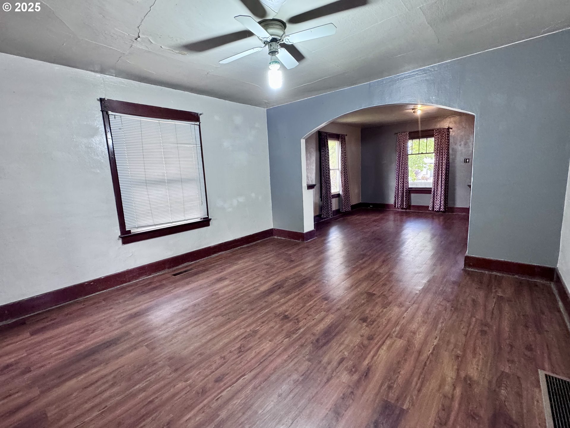 2335 Grace Street Baker City, OR 97814 - Photo 3 of 19 an empty room with wooden floor chandelier fan and windows