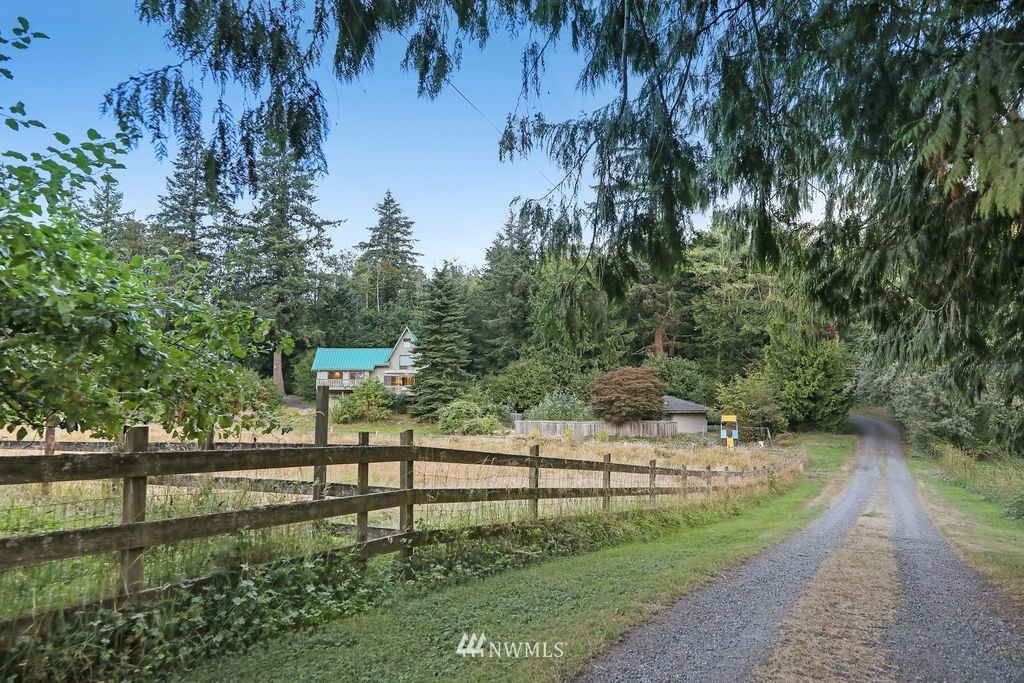 15307 Baker Heights Road Mount Vernon, WA 98273 - Photo 4 of 37 a view of a street with a bench and trees in the background