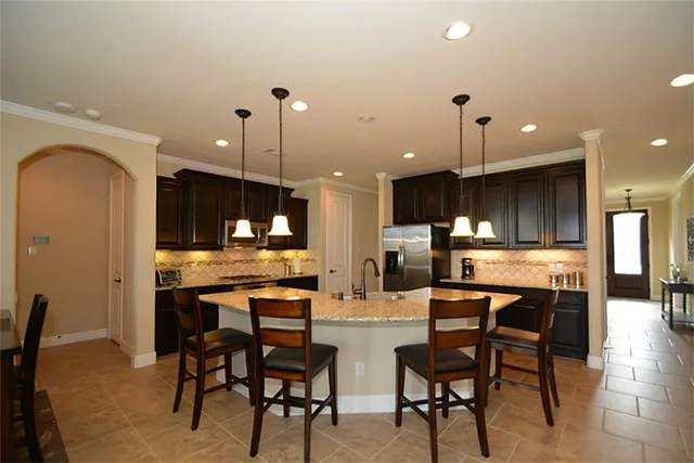 a large kitchen with kitchen island granite countertop a large counter top stainless steel appliances and cabinets