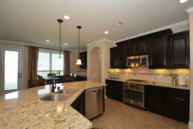 a kitchen with granite countertop stainless steel appliances and wooden cabinets