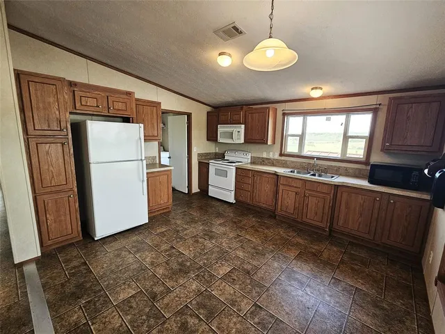 a kitchen with stainless steel appliances granite countertop a refrigerator a stove a sink dishwasher and wooden cabinets