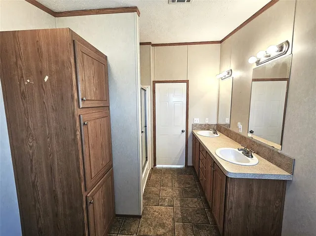 a bathroom with a double vanity sink and mirror with shower
