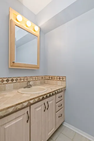 a bathroom with a granite countertop sink and a mirror