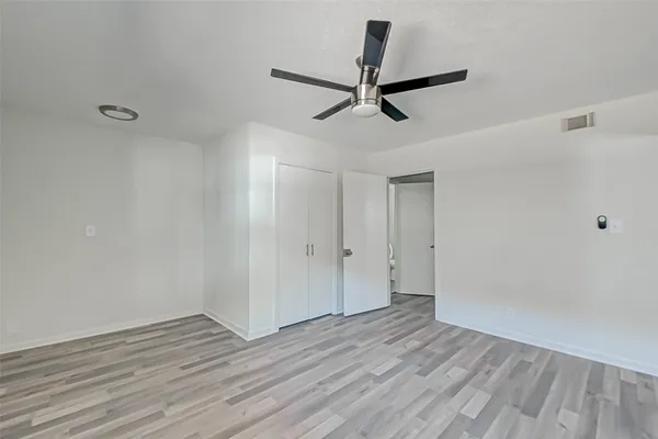 a view of a room with wooden floor and white walls