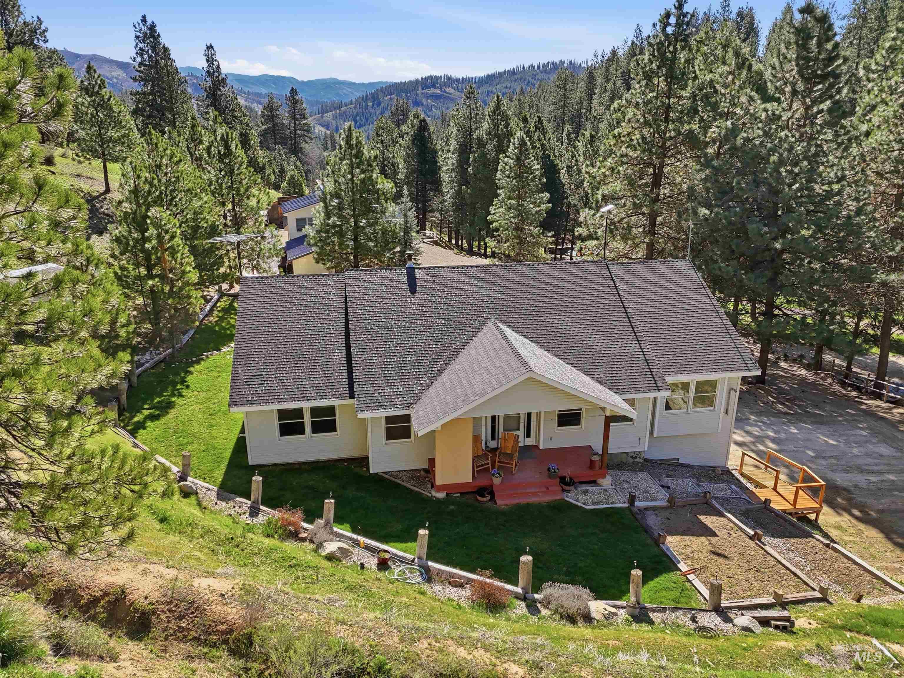 View of subject property featuring a mountainous background and a forest