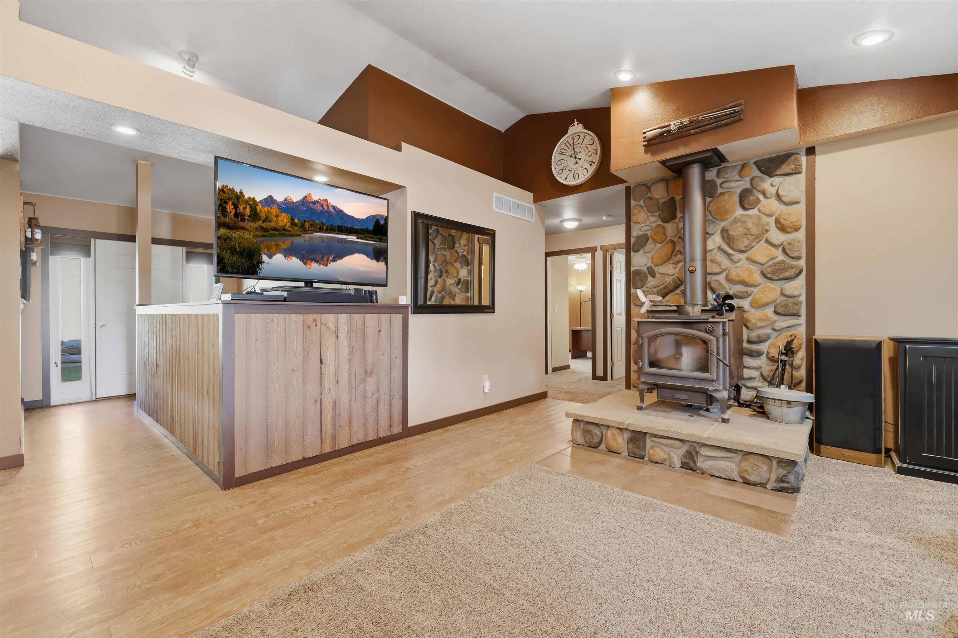 95 Johnson Creek Road Boise, ID 83716 - Photo 17 of 49 Living room with light wood-style floors, lofted ceiling, a wood stove, and recessed lighting