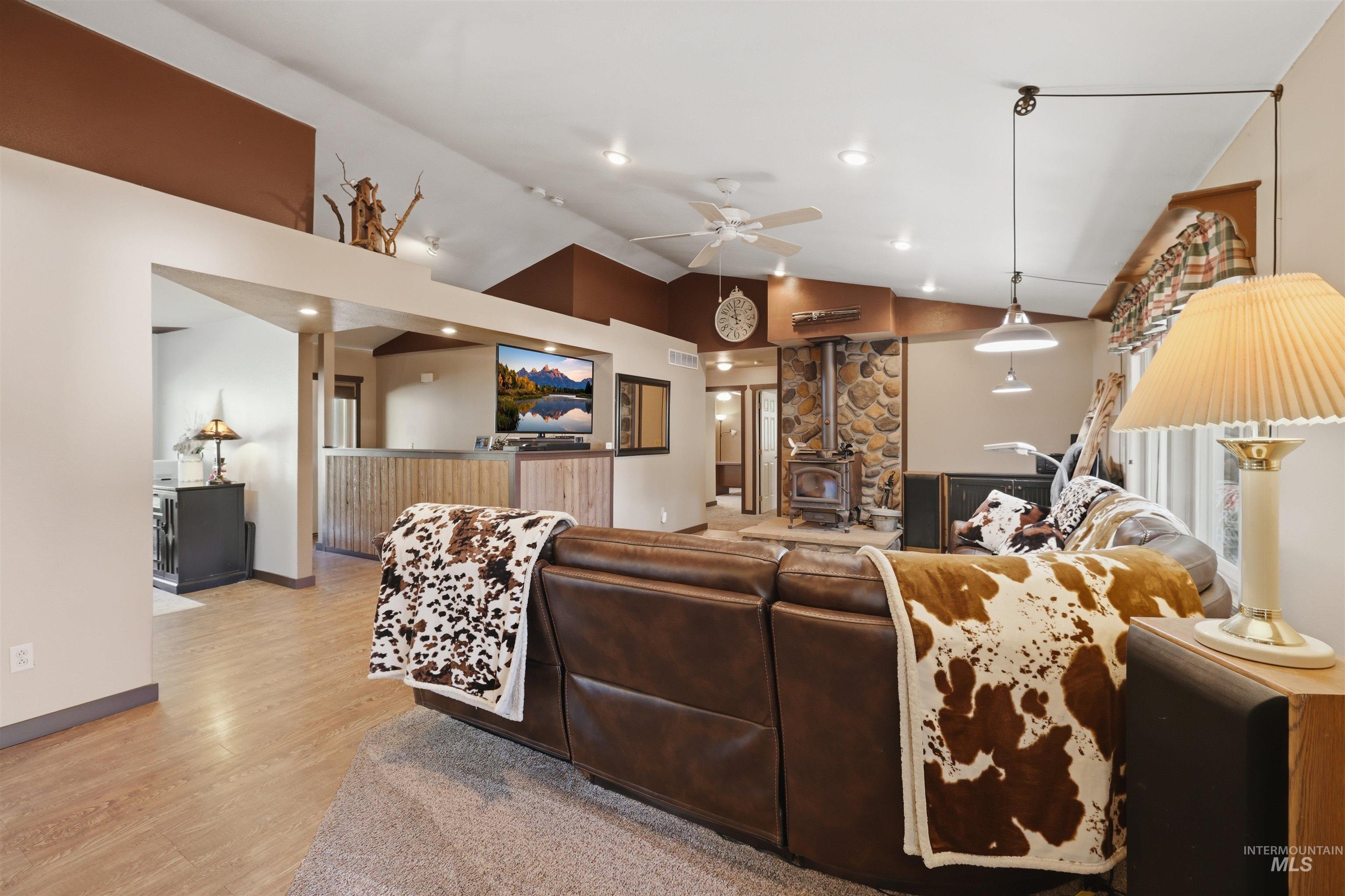 95 Johnson Creek Road Boise, ID 83716 - Photo 18 of 49 Living room featuring a wood stove, light wood-style floors, a ceiling fan, lofted ceiling, and recessed lighting