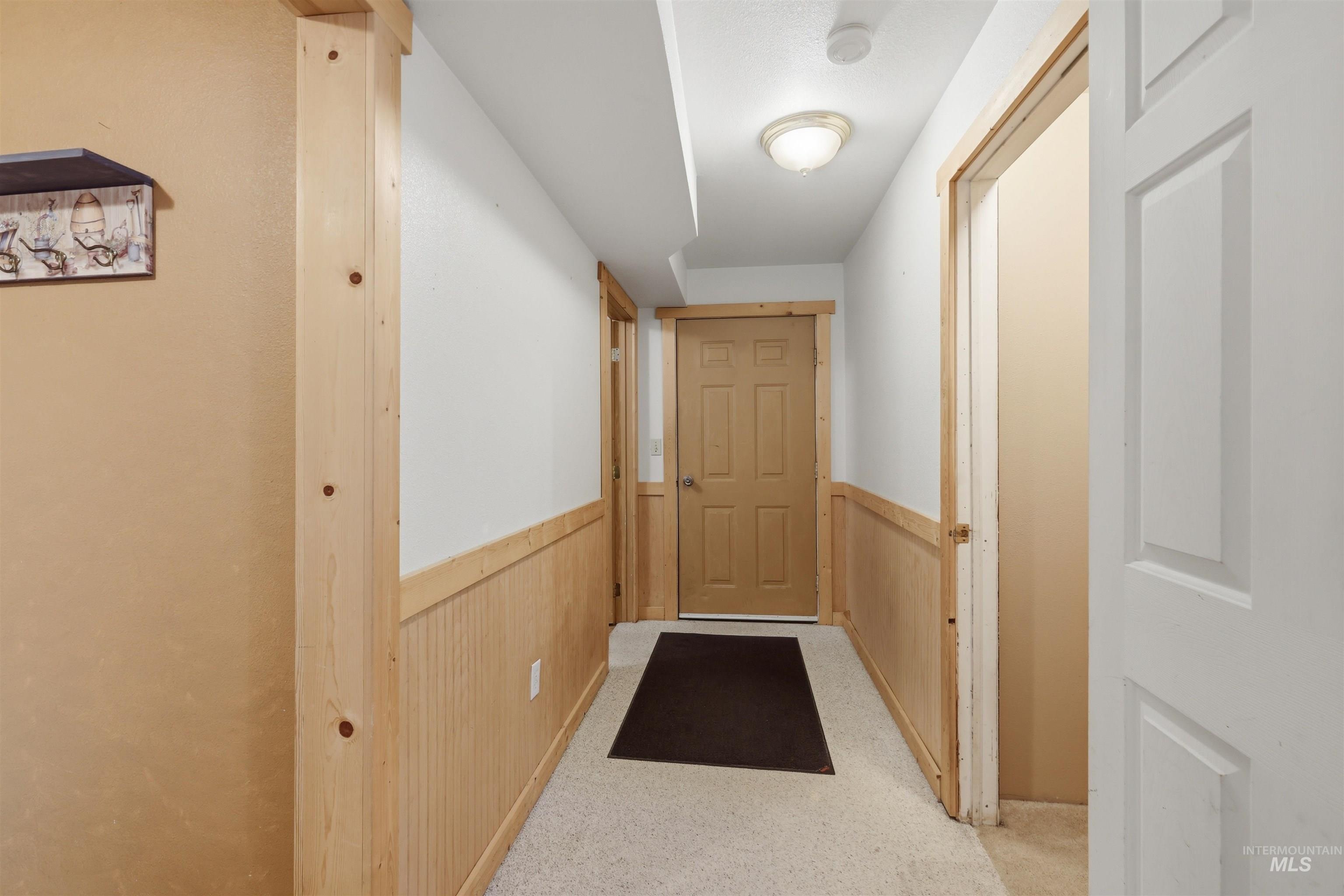 95 Johnson Creek Road Boise, ID 83716 - Photo 36 of 49 Entryway featuring carpet, wood walls, and wainscoting