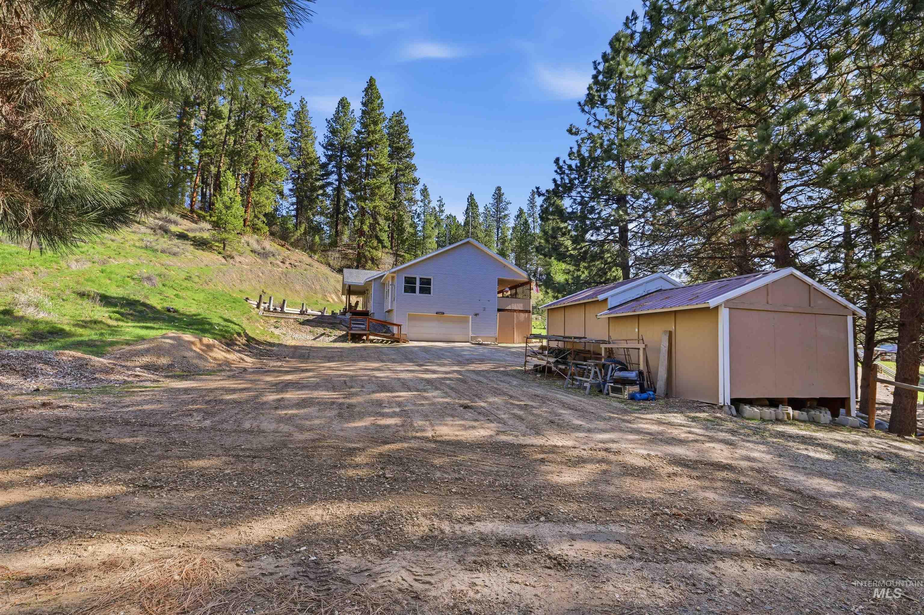 95 Johnson Creek Road Boise, ID 83716 - Photo 48 of 49 View of yard with a garage, dirt driveway, a deck, and a shed