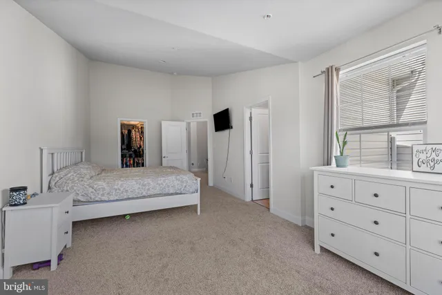 a bedroom with a large bed and a dresser