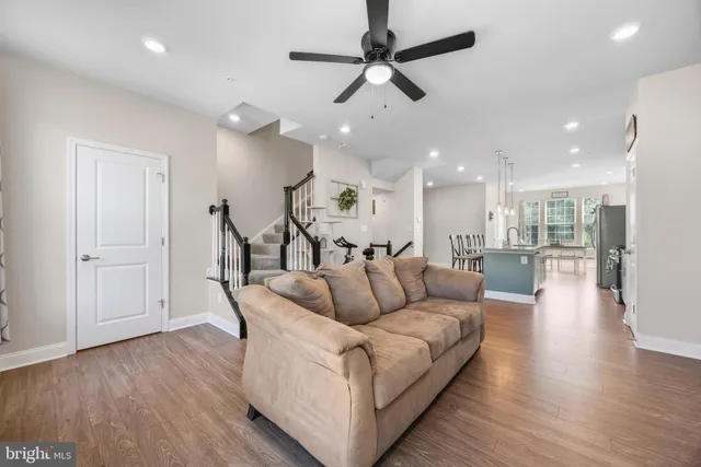 a living room with furniture and a view of kitchen