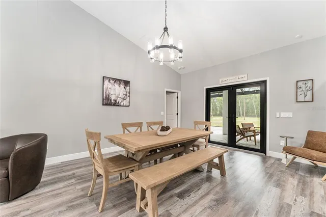 a dining room with wooden floor and a chandelier
