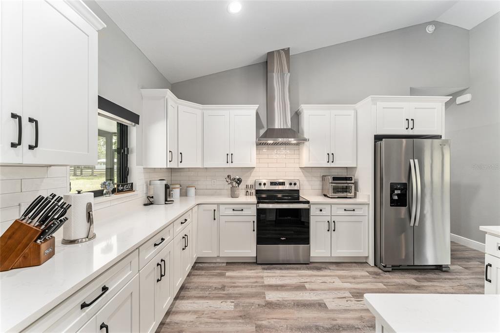 9 Middleground Road Ocala, FL 34482 - Photo 15 of 42 a kitchen with stainless steel appliances granite countertop a sink stove and refrigerator