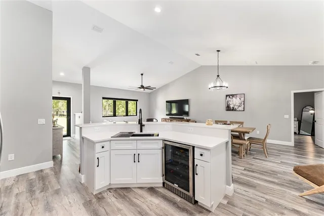 a kitchen with a stove a sink a dining table and chairs with wooden floor
