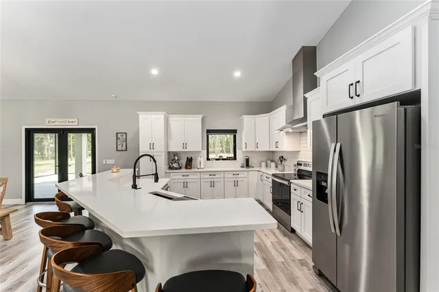 a kitchen with refrigerator cabinets table and chairs