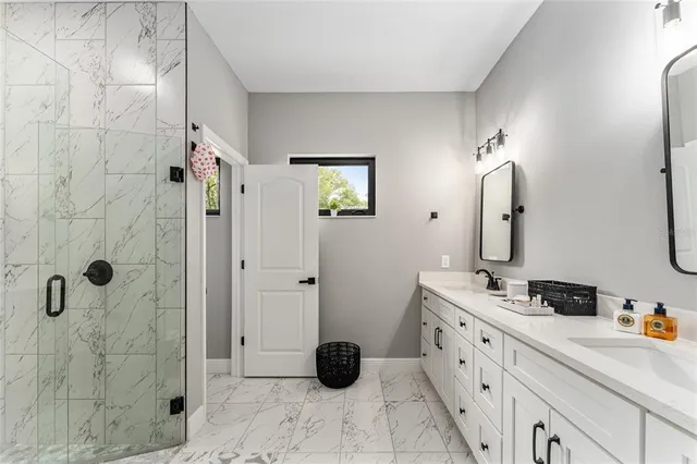 a bathroom with a double vanity sink toilet and shower
