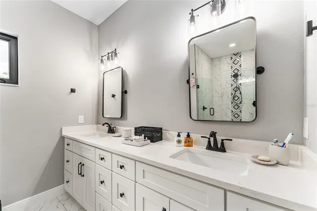 a bathroom with double vanity sinks and a mirror