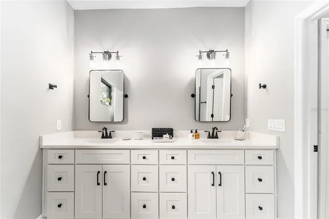 a bathroom with a double vanity sink mirror and