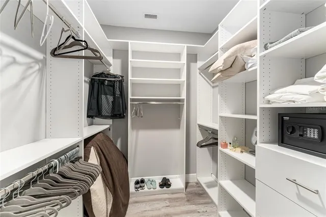 a view of walk in closet with clothes and shoes