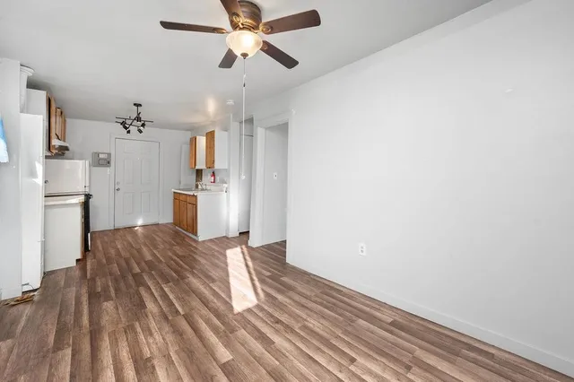 a view of empty room with window and ceiling fan