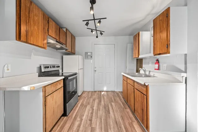 a kitchen with stainless steel appliances granite countertop a refrigerator stove a sink and dishwasher
