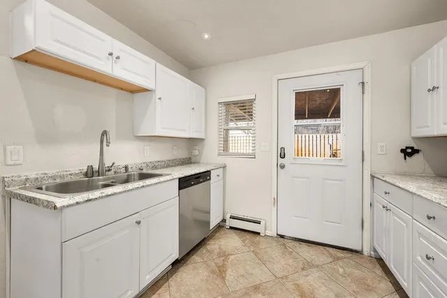 a kitchen with white cabinets and white appliances