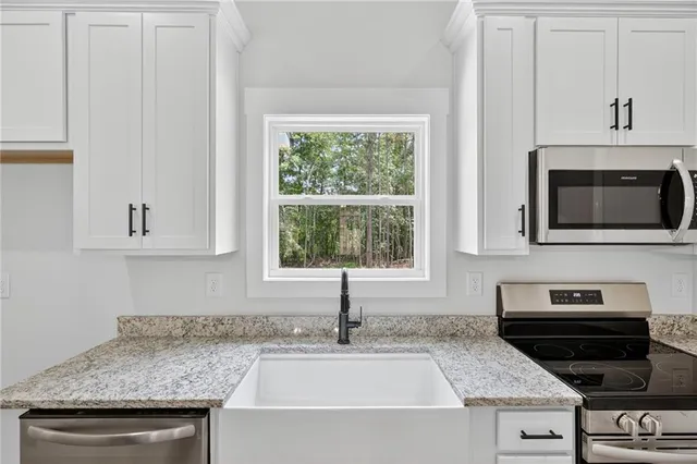 a kitchen with stainless steel appliances granite countertop a sink and a microwave