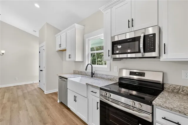 a kitchen with stainless steel appliances a stove microwave and sink