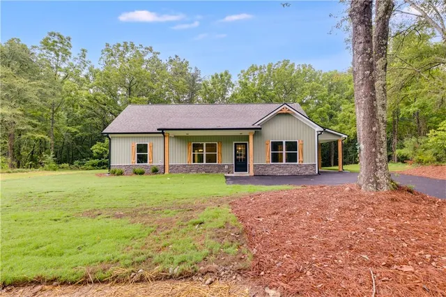 a aerial view of a house next to a yard with large trees