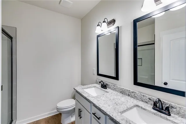 a bathroom with a granite countertop toilet sink and mirror