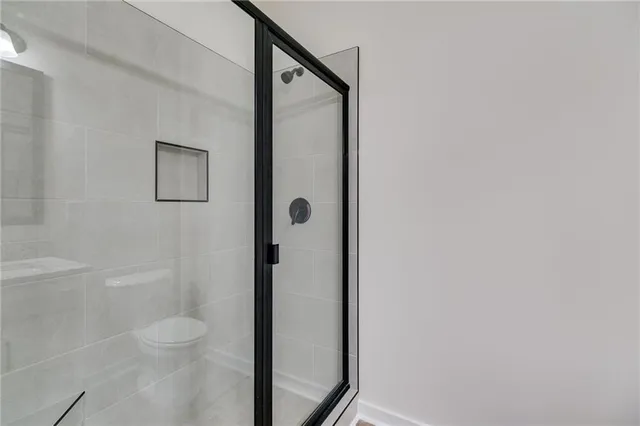 a bathroom with a granite countertop white toilet and a shower