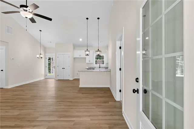 a view of a kitchen with wooden floor and a ceiling fan