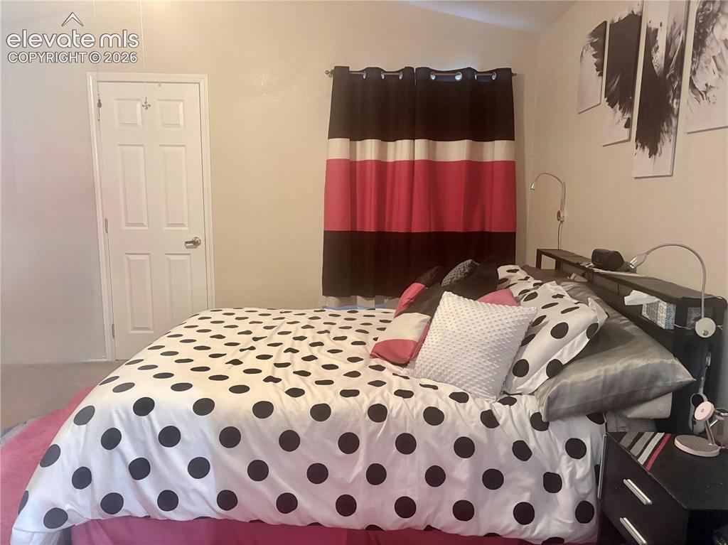 3748 Riviera Grove, Unit 203 Colorado Springs, CO 80922 - Photo 18 of 23 a bedroom with a bed and wooden floor