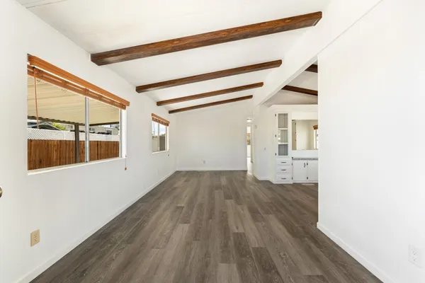 a view of empty room with wooden floor and windows